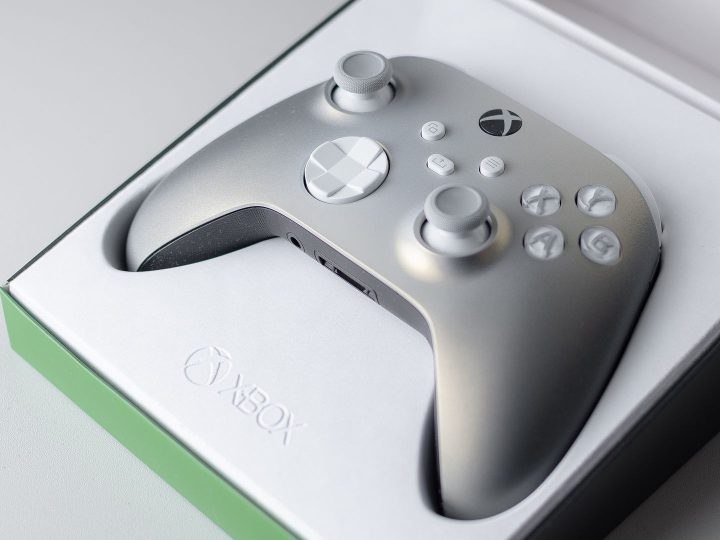 A high quality close up of an Xbox game controller in its packaging box, ready for gaming.